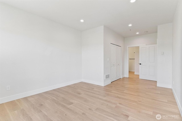 empty room featuring baseboards, recessed lighting, and light wood-style floors