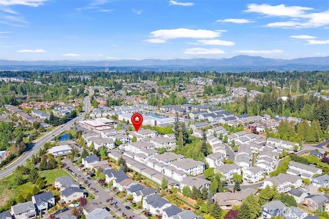 aerial view of property and surrounding area with a mountainous background and nearby suburban area