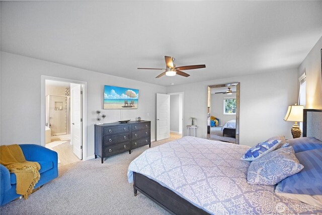 carpeted bedroom featuring a ceiling fan, ensuite bath, and baseboards