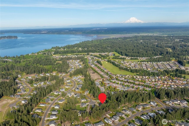 aerial overview of property's location featuring a forest, a large body of water, and nearby suburban area