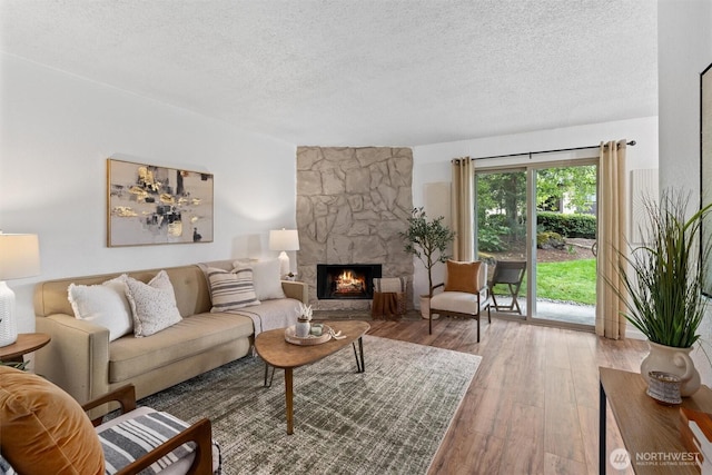 12515 NE 145th Pl Unit D121, Kirkland, WA 98034 - living room with a textured ceiling, wood-type flooring, and a stone fireplace