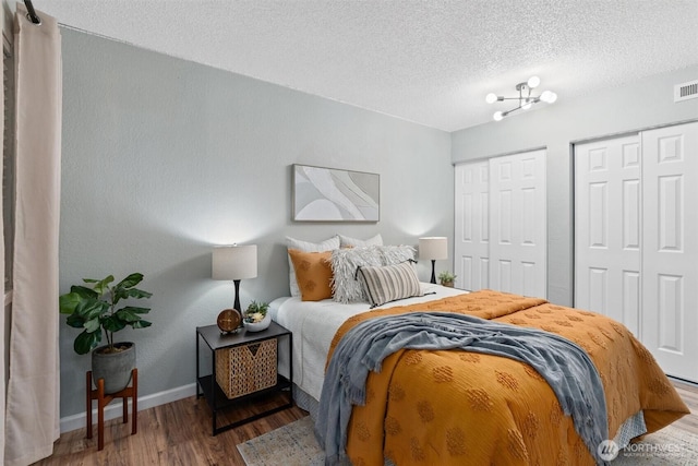 12515 NE 145th Pl Unit D121, Kirkland, WA 98034 - bedroom featuring multiple closets, wood finished floors, a textured ceiling, and baseboards