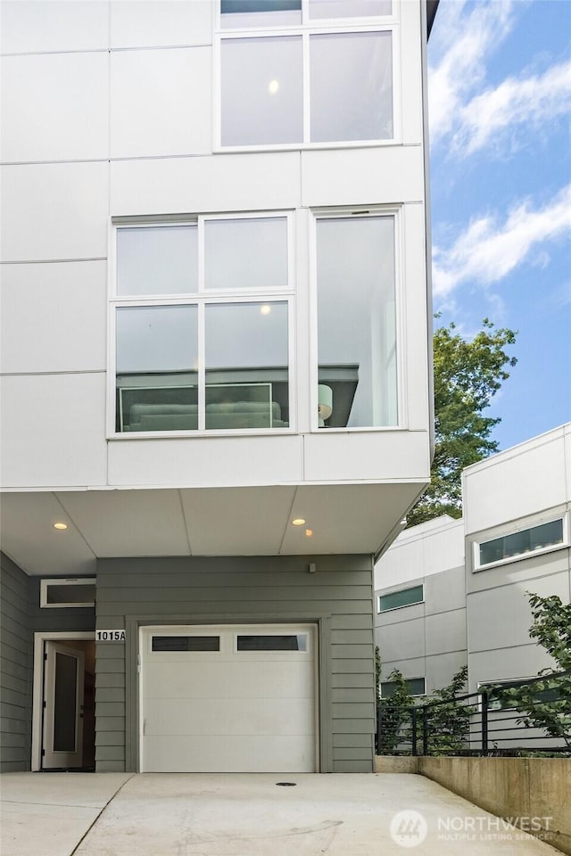 view of front of home with concrete driveway, an attached garage, and a carport