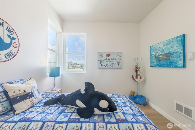 bedroom featuring visible vents, wood finished floors, and baseboards