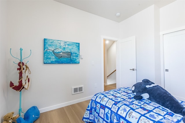 bedroom with light wood finished floors, baseboards, and visible vents