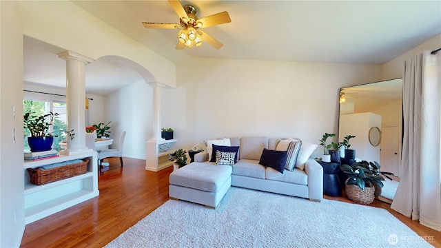 living area with ceiling fan, wood finished floors, arched walkways, and decorative columns