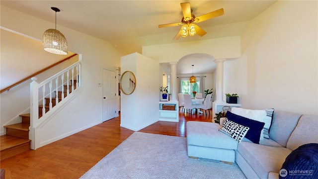 living room with lofted ceiling, baseboards, ceiling fan, wood finished floors, and ornate columns