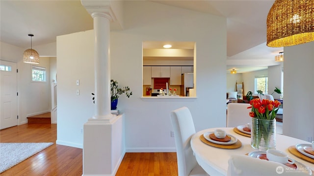 dining area featuring baseboards, decorative columns, and hardwood / wood-style flooring