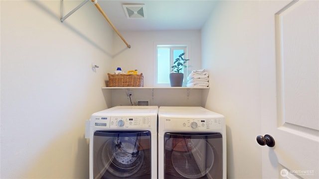 clothes washing area with washing machine and clothes dryer and laundry area