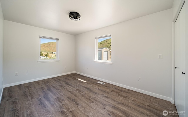 10 Spring Canyon Rd, Orondo, WA 98843 - spare room featuring plenty of natural light, dark wood-style floors, and baseboards