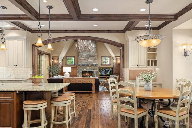 2045 250th Pl NE, Sammamish, WA 98074 - dining space with dark wood finished floors, beamed ceiling, coffered ceiling, a stone fireplace, and arched walkways