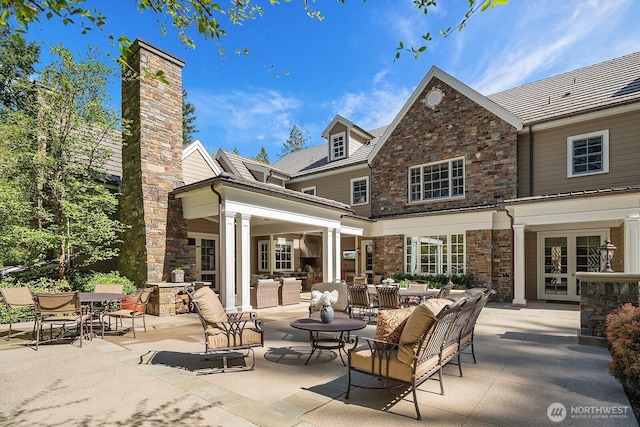 2045 250th Pl NE, Sammamish, WA 98074 - back of property featuring stone siding, a patio area, an outdoor hangout area, outdoor dining area, and french doors