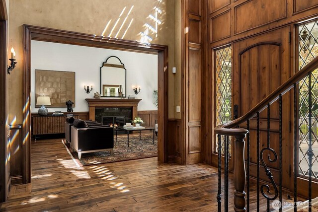 2045 250th Pl NE, Sammamish, WA 98074 - entrance foyer featuring a towering ceiling, dark wood finished floors, a high end fireplace, stairs, and a wainscoted wall