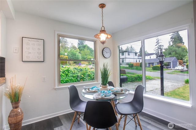 dining area featuring baseboards and dark wood-style flooring