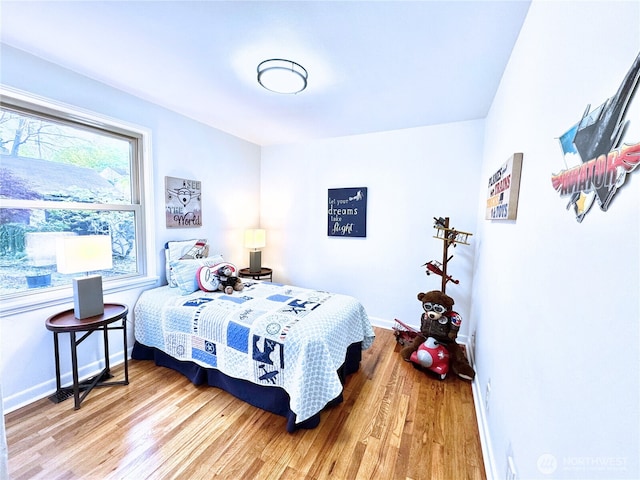 bedroom featuring light wood-style floors and baseboards