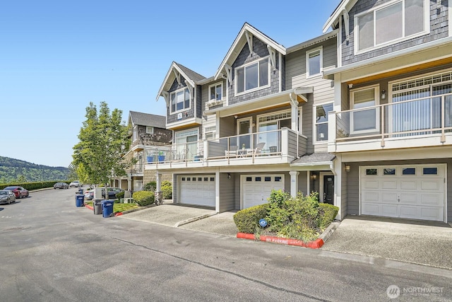view of front of house with a garage, driveway, and a balcony