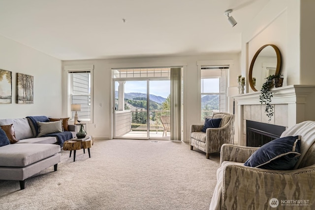 carpeted living room featuring a mountain view and a fireplace