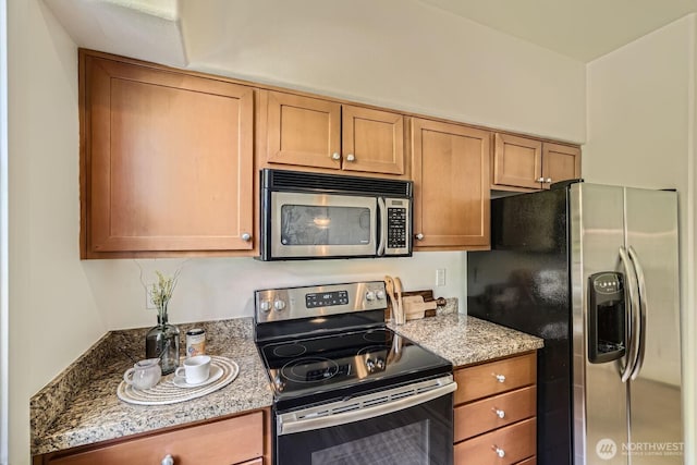 kitchen with appliances with stainless steel finishes and light stone counters