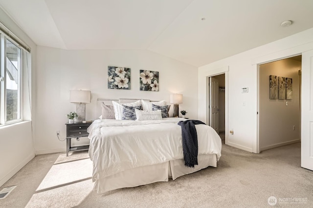 bedroom featuring lofted ceiling, light colored carpet, and baseboards