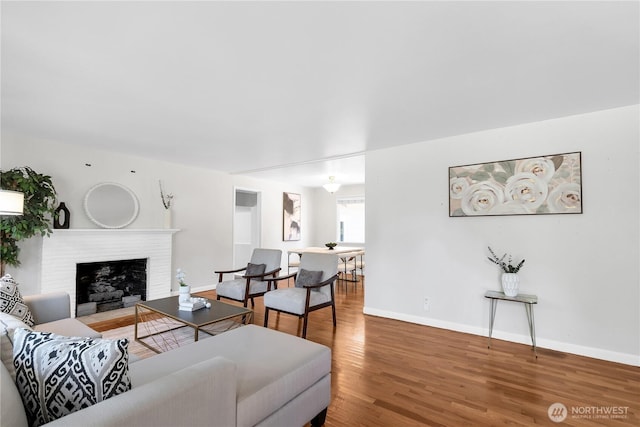 living room with wood finished floors, baseboards, and a fireplace