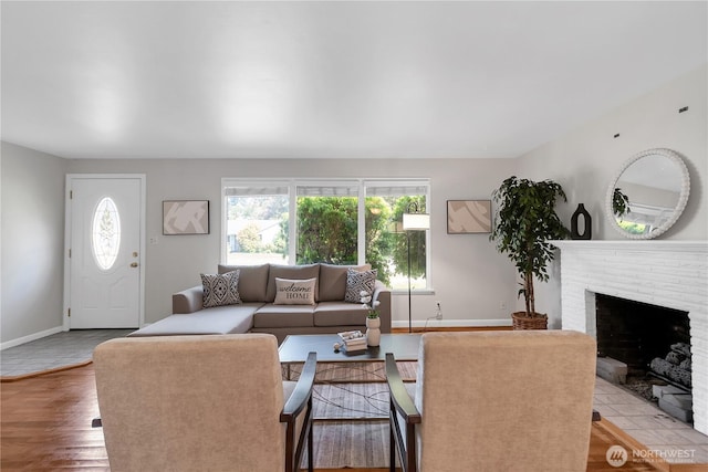 living room with baseboards, wood finished floors, and a fireplace