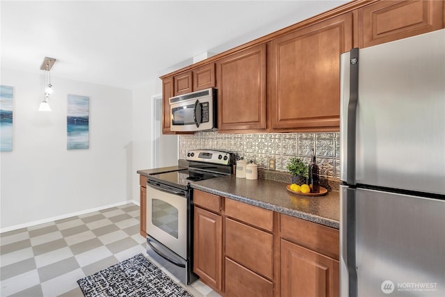 kitchen featuring appliances with stainless steel finishes, light floors, dark countertops, backsplash, and brown cabinetry
