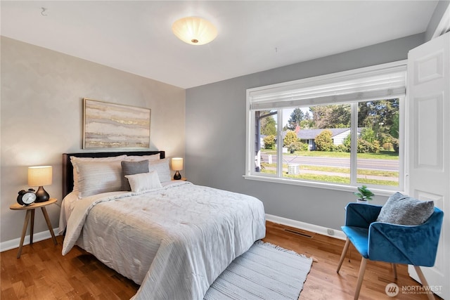 bedroom with baseboards and wood finished floors