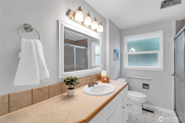 full bathroom featuring a shower stall, vanity, plenty of natural light, and toilet