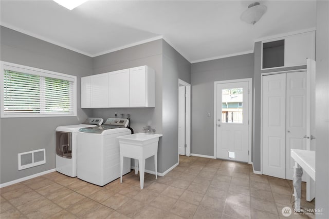 laundry room with cabinet space, washer and dryer, crown molding, and baseboards