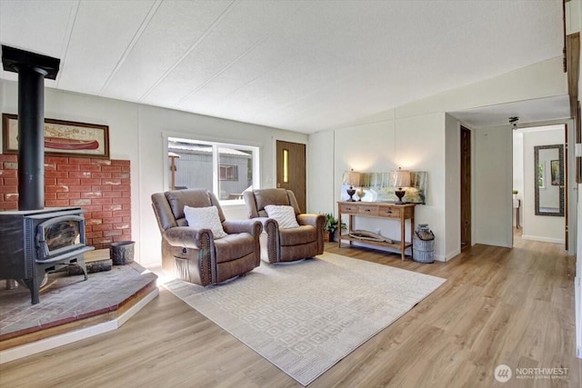 living area featuring a wood stove and light wood-style flooring
