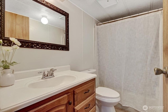 bathroom featuring toilet, vanity, and curtained shower