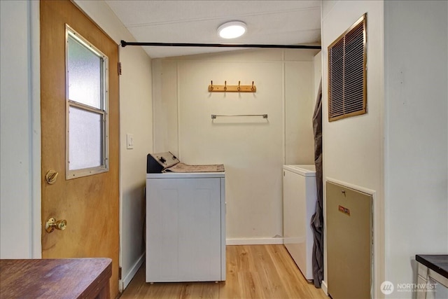 laundry area with laundry area, washer and clothes dryer, baseboards, and light wood-type flooring