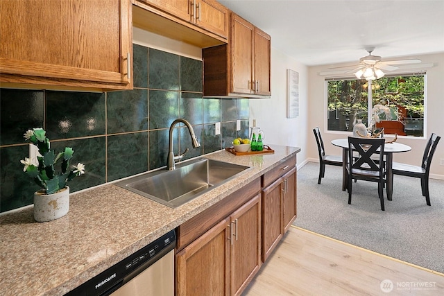 kitchen with a sink, dishwasher, decorative backsplash, and brown cabinets