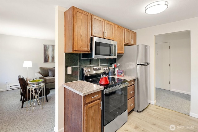 kitchen featuring stainless steel appliances, light countertops, tasteful backsplash, and baseboards