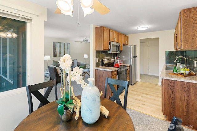 dining room featuring a ceiling fan and light wood finished floors