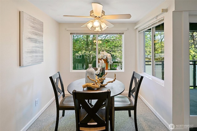 carpeted dining space featuring plenty of natural light, baseboards, and ceiling fan
