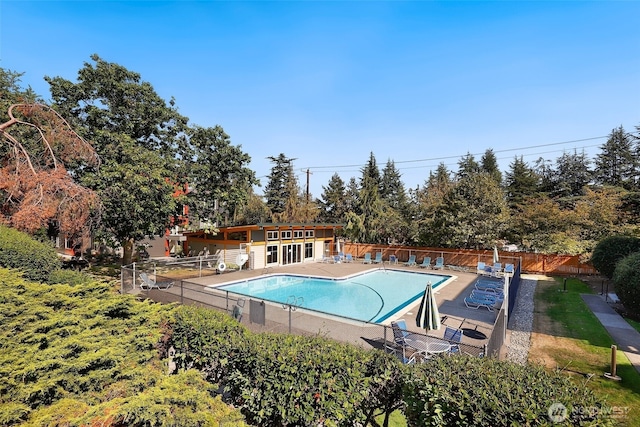 community pool featuring fence and a patio