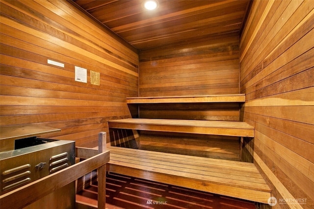 relaxing sauna featuring wood ceiling and wooden walls