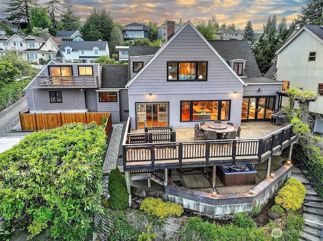 back of property at dusk featuring a wooden deck