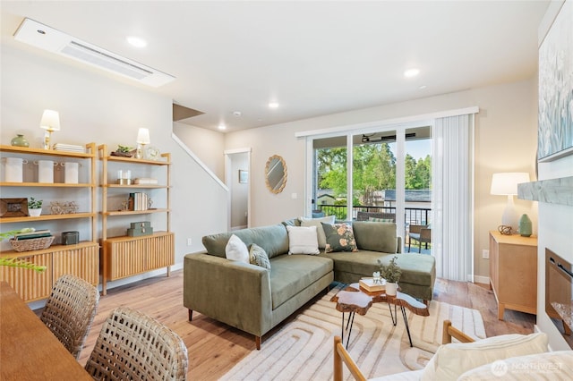 living area featuring light wood finished floors, baseboards, and recessed lighting