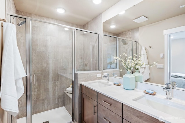 bathroom featuring a sink, double vanity, and a shower stall