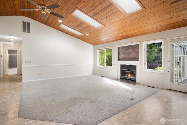 unfurnished living room with a fireplace with flush hearth, wooden ceiling, visible vents, and a skylight