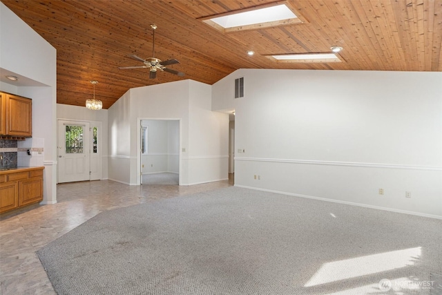 unfurnished living room featuring a ceiling fan, a skylight, visible vents, baseboards, and wooden ceiling