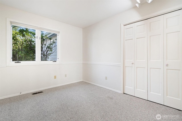 unfurnished bedroom with carpet, visible vents, and baseboards