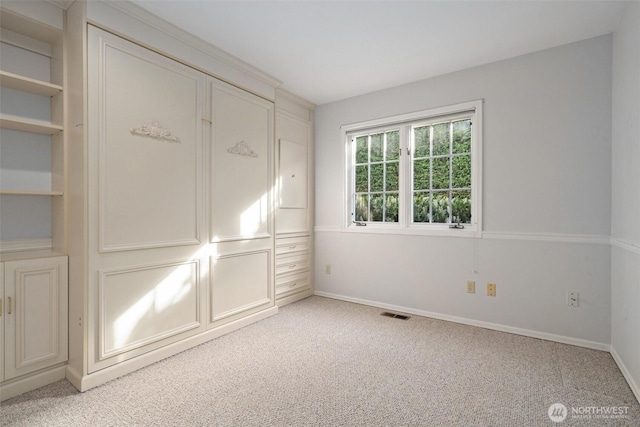 spare room with light carpet, baseboards, and visible vents