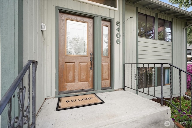 view of exterior entry featuring a porch and board and batten siding