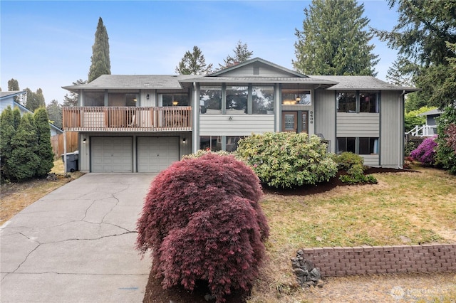 view of front of home featuring an attached garage, a balcony, driveway, and a front lawn