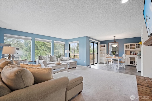 living room with a textured ceiling, plenty of natural light, recessed lighting, and baseboards