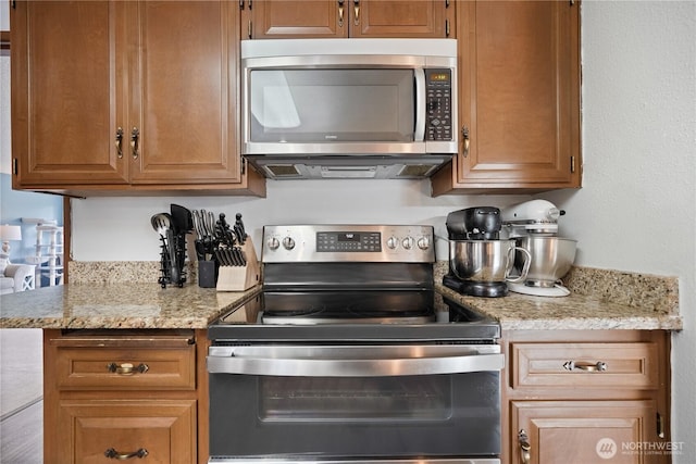 kitchen featuring stainless steel appliances and light stone counters
