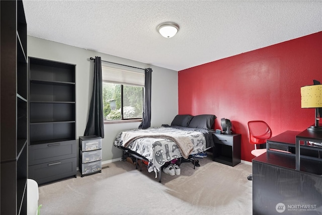 carpeted bedroom with a textured ceiling, baseboards, and an office area